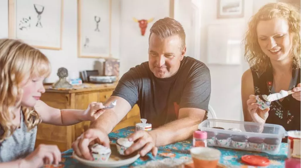 rodzice wraz z dzieckiem robią wspólnie babeczki w salonie ogrzewanym kotłem gazowym